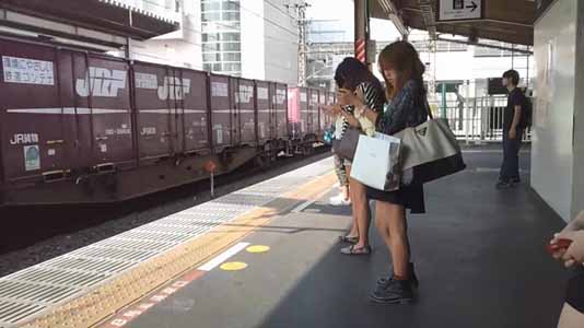 駅のホームで電車を待つヒラヒラのミニスカートをはいたギャル。