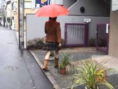 赤い傘をさして歩いているミニスカ女子