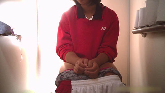 赤のスポーツウェアを着る女子が便座に座ってます