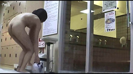 体重を量ろうとするスタイルの良いママが荷物を置いて前かがみ