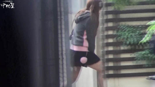 道路から建物のスキマに入って行くギャル