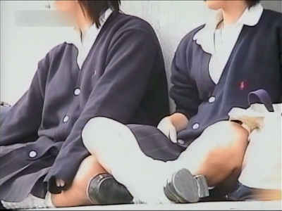 地べた座りのJK二人、制服であぐらをかいてます